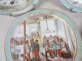 three plates with pictures of people and a dog on them