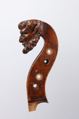 un gros plan d'un violon avec une tête gravée sur le dos