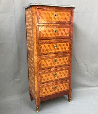 an old wooden chest of drawers with a marble top