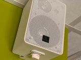 a white speaker on a green wall in a room
