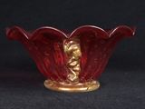 an image of a red glass bowl with a gold decoration on it
