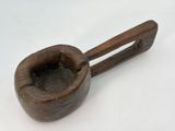 a small wooden pipe with a wooden handle on a white surface