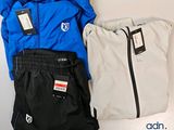 trois paires de pantalons et une veste posés sur une table