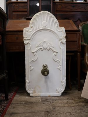 une porte blanche munie d'une poignée dorée, dans une pièce