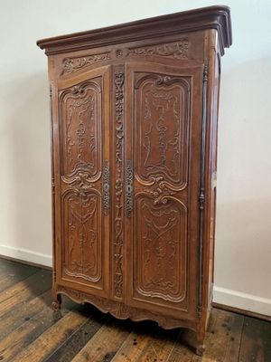 an old wooden armoire with carvings on the top of it