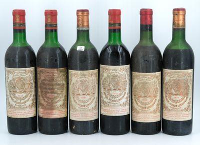 six bottles of wine are lined up in a row on a white surface