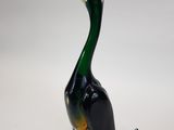 a glass duck that is sitting on a white surface