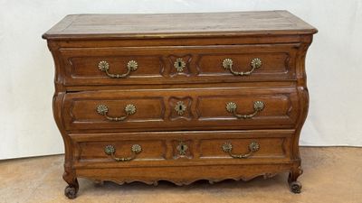 an old wooden chest of drawers with brass hardware on top of it