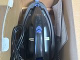 a black and blue steam iron in a cardboard box