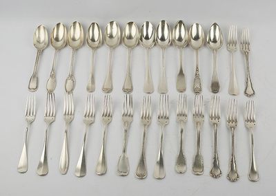 a lot of silver spoons and forks laid out on a table