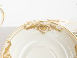 a lot of white and gold plates on a table