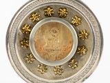 a silver plate with a coin in the middle of it