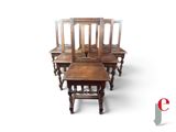 four wooden chairs and a table with a glass top on a white background