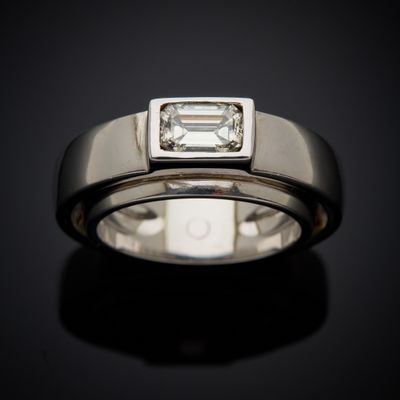 a close up of a ring with an emerald stone in the center