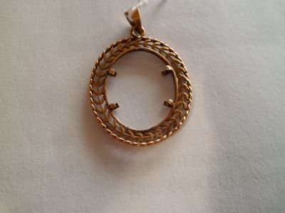 une photo d'un pendentif plaqué or posé sur un tissu blanc