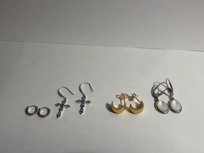 three pairs of earrings and a ring on a table