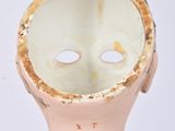 a small doll with a white mask on it ' s head