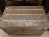 an old trunk sitting on the floor next to a dresser