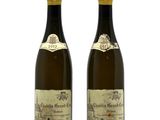 two bottles of wine sitting next to each other on a white surface