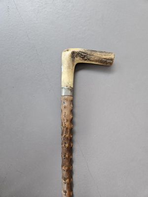 a close up of a wooden stick with a handle on a gray surface