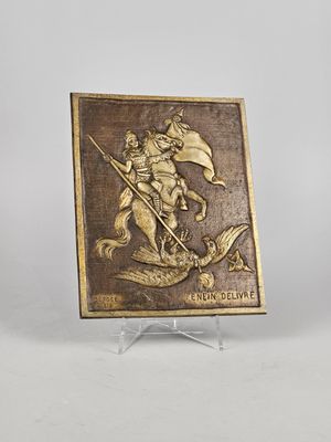 bronze plaque depicting a man riding a horse with a flag on it