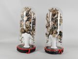 two vases with flowers inside of them on a table
