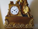 une horloge en or posée sur une table en bois