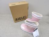 a pair of pink rain boots on the ground next to a box