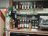 many bottles of alcohol on the counter behind the coffee machine
