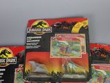 three boxed jurassic park toys including a car and a dinosaur