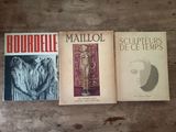three books on a table with a wooden table in the background