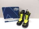 pair of black and yellow boots with yellow laces and a blue box