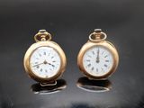 deux horloges posées sur une table, sur fond noir
