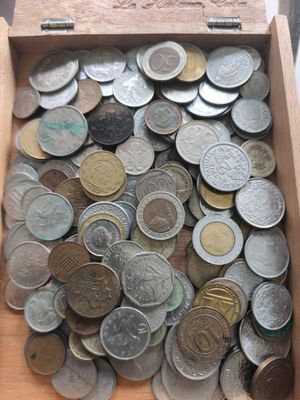 une boîte en bois remplie de pièces posée sur une table