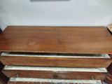 a wooden chest of drawers sitting on a table