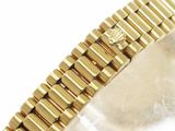 a close up of a gold bracelet on a white surface