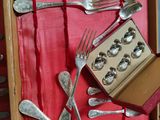 many spoons and forks in a box on a table