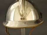 silver helmet on a metal stand against a gray background