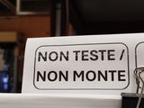 a paper clip attached to a sign that says non teste / non monte