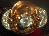 une bague en or sertie d'un diamant, posée sur un tissu rouge