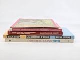 three books stacked on top of each other on a white surface
