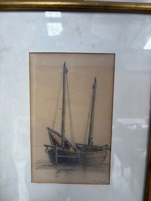 tableau représentant un bateau, dans un cadre doré, posé sur une table