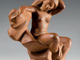 une image représentant une sculpture d'une femme assise sur un rocher