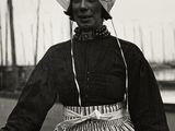 une vieille photo en noir et blanc représentant une femme en robe et chapeau