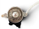 a white pearl in the middle of a silver and gold ring