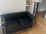 un canapé en cuir noir dans un coin du salon