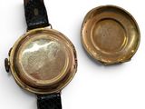 two watches sitting next to each other on a white surface