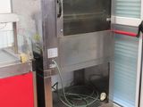un homme debout devant un four dans une cuisine