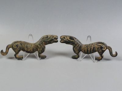 two figurines of horses are standing next to each other on a white surface