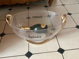 a glass bowl with a bottle in it on the floor